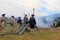 Somber view of young men firing canons during war reenactments, Fort Ticonderoga, New York, 2016