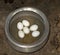 Some boiled poultry eggs kept on a aluminum pan close up.