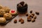 Some catalan panellets, almonds and roasted chesnuts on a wooden table. Typical in La Castanyada, Catalonia, Spain