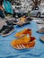 some colorful sneakers laid out on a blue blanket near a white car