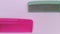 Some combs in pink and green on a white background