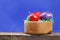 Some Easter eggs in a wooden bowl on a board, blue background
