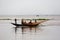 Some fishermen are catching fish with long fishnet from traditional fish-boat in the Meghna river at