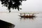 Some fishermen are catching fish with long fishnet from traditional fish-boat in the Meghna river at