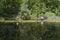 Some fishermen, immersed in the quiet waters of a lake, are dedicated to sport fishing on a quiet summer afternoon.