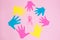 Some handprints of different colors forming a circle and pink ribbon inside