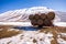 Some hay bales in the snow in Pian grande and Mount Vettore in the background, Castelluccio di Norcia, Umbria, Italy