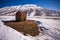 Some hay bales in the snow in Pian grande and Mount Vettore in the background, Castelluccio di Norcia, Umbria, Italy