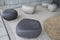 Some large smooth surface rocks with indented top surfaces designed for sitting placed on ceramic floor
