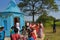 Some men and women performing puja rituals by walking round the temple and distributing sweets to the children