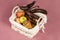 Some overripe fruits in white wicker basket with dirty napkin, tainted bananas, half-peeled and rotten, apples with decay spots on