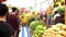 Some people wearing face masks choose and buy fruits and vegetables in a stand in a street market, af