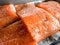 Some pieces of fillet of raw red fish with spices lie on a baking sheet before smoking, black pepper and salt, salmon