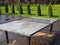 Some ping pong tables in a public park. Outdoor playground with many tennis tables