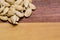 Some pumpkin seeds on a two-colored wooden surface.