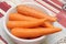 Some raw uncooked carrots sitting on a plastic white bowl