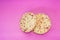 Some round crackers with red marks isolated on the pink background