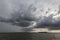 Some spectacular and menacing clouds over a lake, with a distant