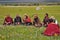 Some Tibetans chatting, sitting on the prairie