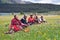 Some Tibetans chatting, sitting on the prairie