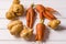 Some ugly curved carrots and potatoes on white wooden background