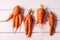 Some ugly curved carrots on white wooden background