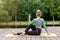 A some woman on a wooden platform in summer, does yoga