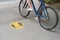Someone riding a bike next to a social distance sign drawn on the ground during covid pandemic