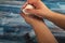 Someone is soaping their hands with a piece of toilet soap on a wooden background. Close up. Personal hygiene is the prevention of