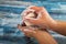 Someone is soaping their hands with a piece of toilet soap on a wooden background. Frequent hand washing with soap is a prevention