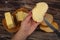 Someone spreads a little butter with a knife on fresh wheat toast, a piece of butter in a wooden butter dish, and fresh wheat