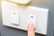 Someone trying to use index finger to pressing a switch. there is yellow ray light located on top rigth of frame