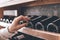 Sommelier Concept. Senior man standing touching wine bottles in cabinet close-up