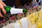 Sommelier hand pours white sparkling wine into wineglasses at an open air summer party catering