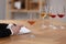 Sommelier making notes during wine tasting at table indoors, closeup