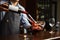 Sommelier pouring wine into glass from decanter. Male waiter