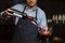 Sommelier pouring wine into glass from decanter. Male waiter