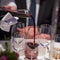 Sommelier pouring wine into glass from mixing bowl, luxury diner