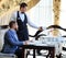 The sommelier pours the wine into the decanter near the guest in the restaurant.