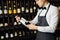 Sommelier presenting bottle of red wine to customer in a wine store