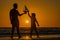 Son and father playing with toy boat in summer sea. Family dream on cruise liner. Father and son playing on the beach at