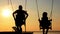 Son and father swinging on a swing at sunset, dawn, near the river, silhouettes