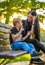 Son Glazing in His Mother`s Eyes on a Park Bench in Autum Colorful Background, Sun Shining over their Faces