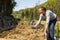 Son helping mother layering straw mulch in a raised garden bed