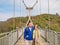 Son and mother Stand on Suspension bridge cross the mountain at tianmen mountain Zhangjiajie china.