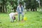 Son planting seedling in ground near father