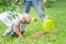 Son planting seedling in ground near father