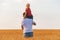 Son sitting on fathers shoulders on field of ripe wheat background. Back view