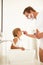 Son Watching Father Shaving In Bathroom Mirror