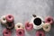 Sone pink and white donuts with cup of coffee over grey stone te